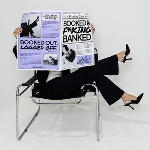 Person sitting in a chair holding a newspaper with provocative headlines.