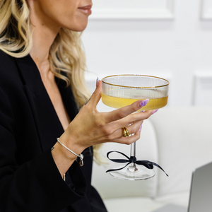 Woman holding a cocktail glass with a blurred background