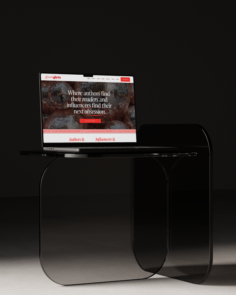 Modern black glass table with a laptop displaying a webpage on a dark background