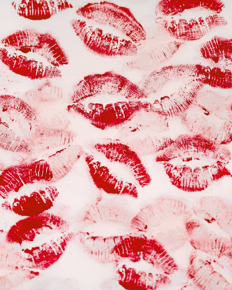 Pattern of red lipstick kisses on a white background