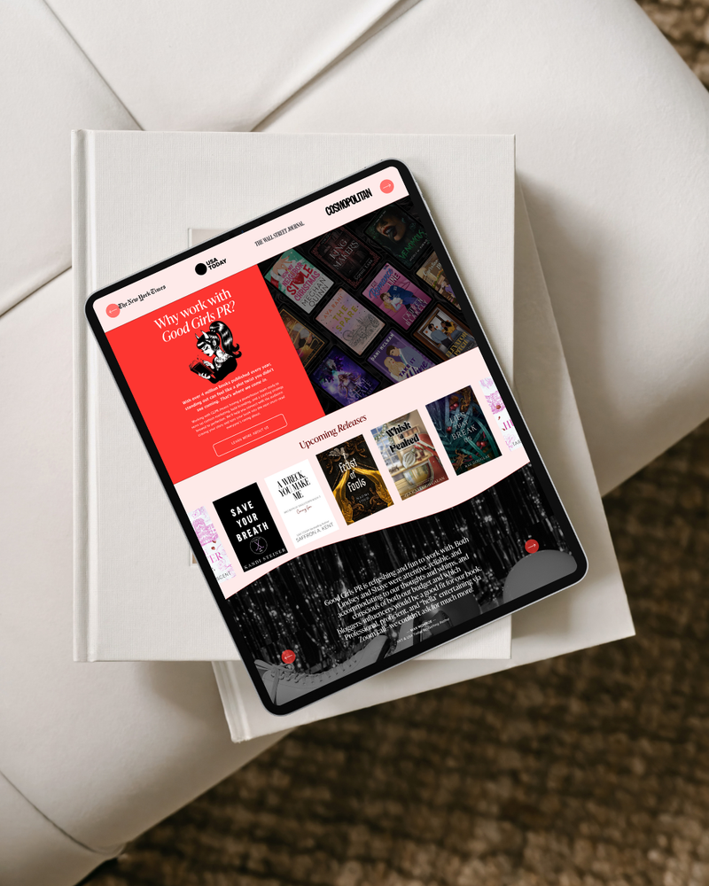 Tablet displaying a website on top of a book with a white surface underneath