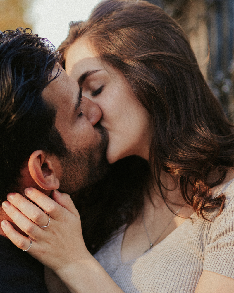 Two people kissing with a warm, intimate atmosphere.